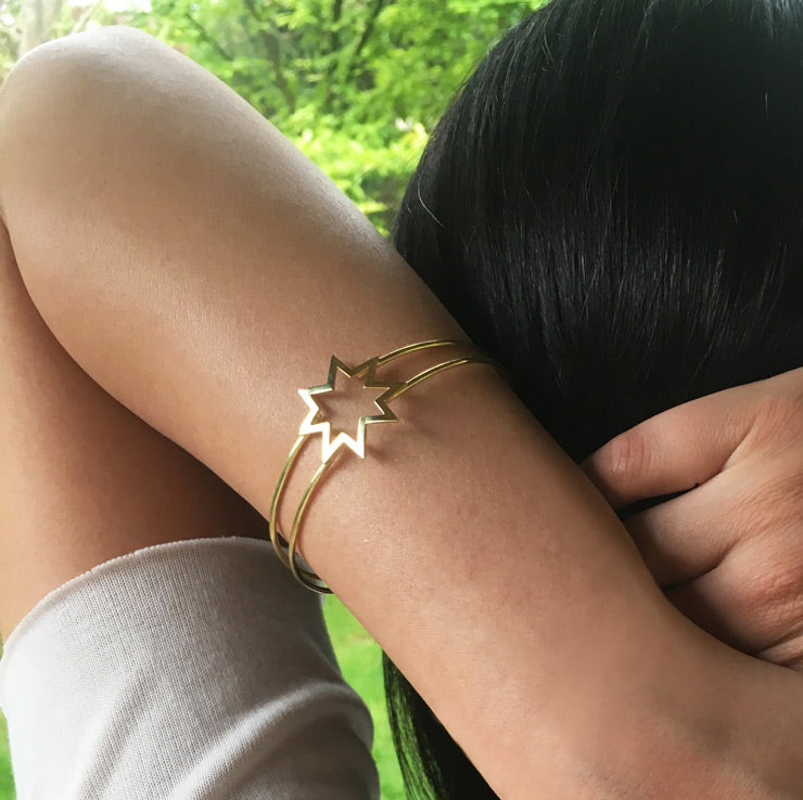 Arkasi donuk ve elini ensesine koymus kizin kolunda yildiz bilezik_Star bracelet on the arm of a girl with her back turned