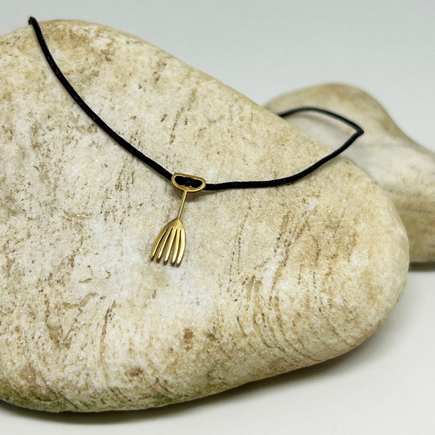 Bej tas ustunde duran el parmak tarak motifli siyah ipli bileklik_Black string bracelet with hand finger and comb motif on a beige stone