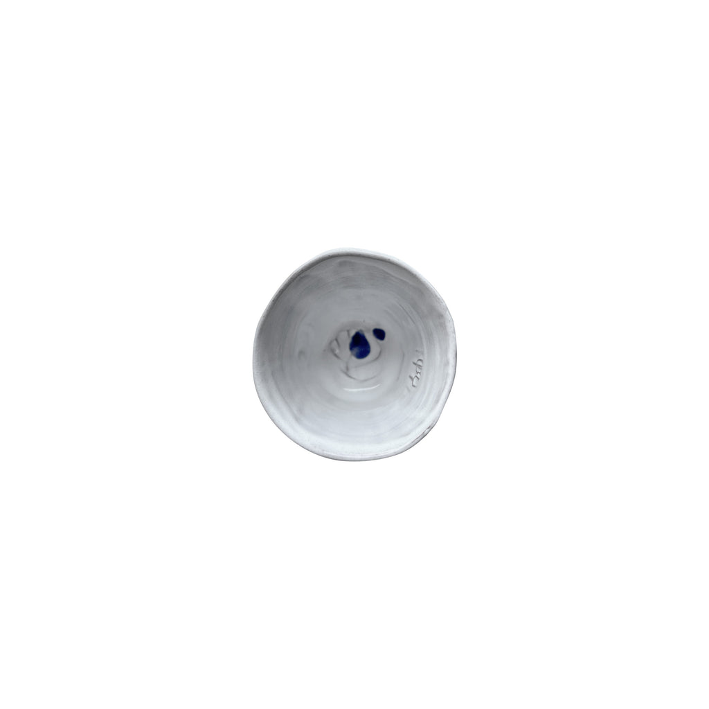 Beyaz seramik bardagin icinde mavi damla desenleri_Blue drip patterns in white ceramic cup