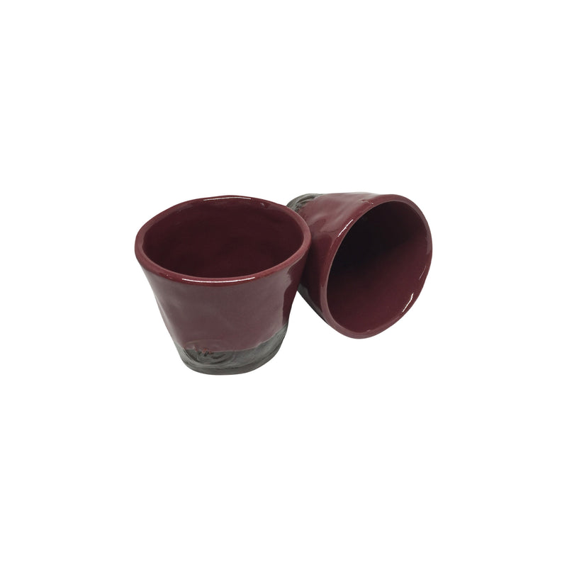 Biri dik digeri yan duran iki adet bordo seramik bardak_Two burgundy ceramic cups one standing upright and the other sideways