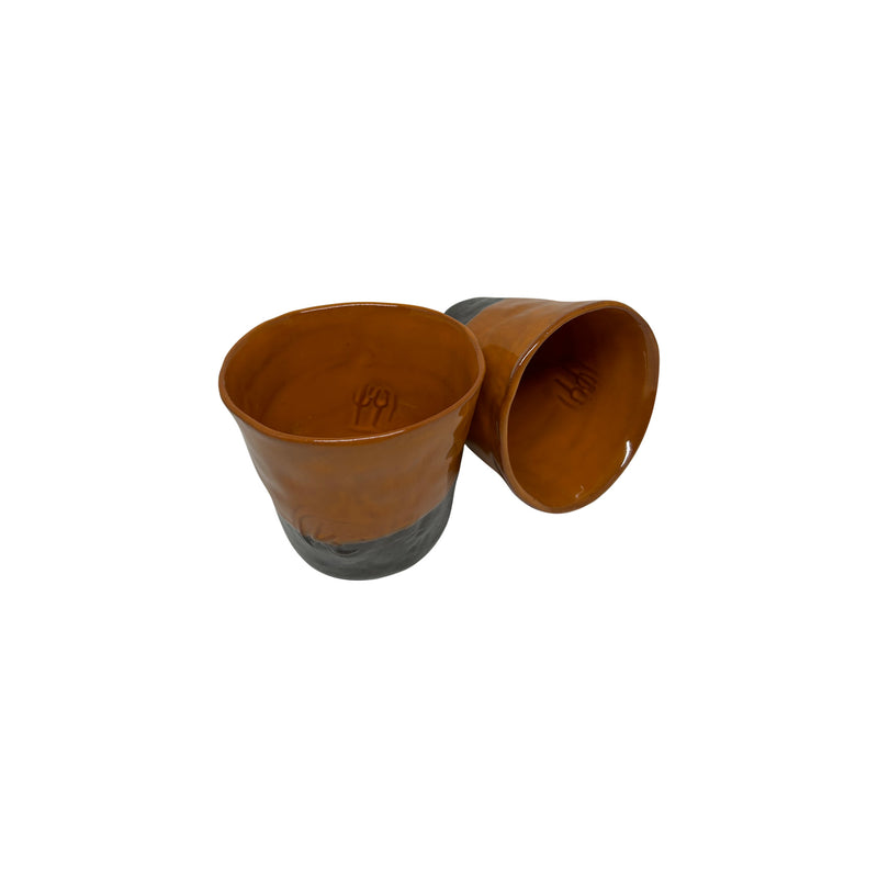 Biri dik digeri yan duran iki adet turuncu seramik bardak_Two orange ceramic cups one standing upright and the other sideways