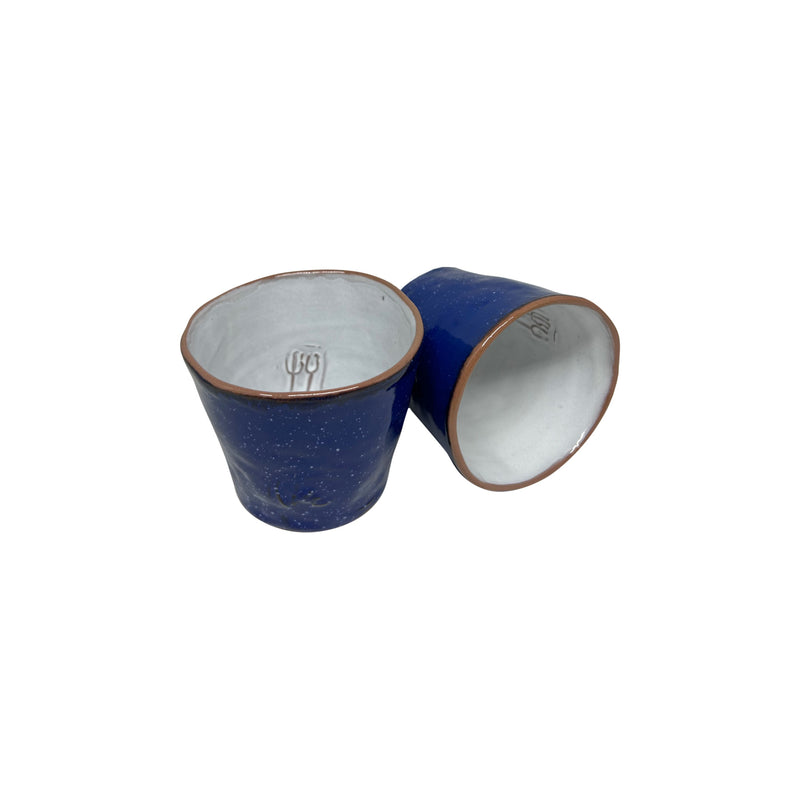 Biri yan yatan iki adet koyu mavi ve beyaz seramik bardak_Two dark blue and white ceramic cups one of which is ranked
