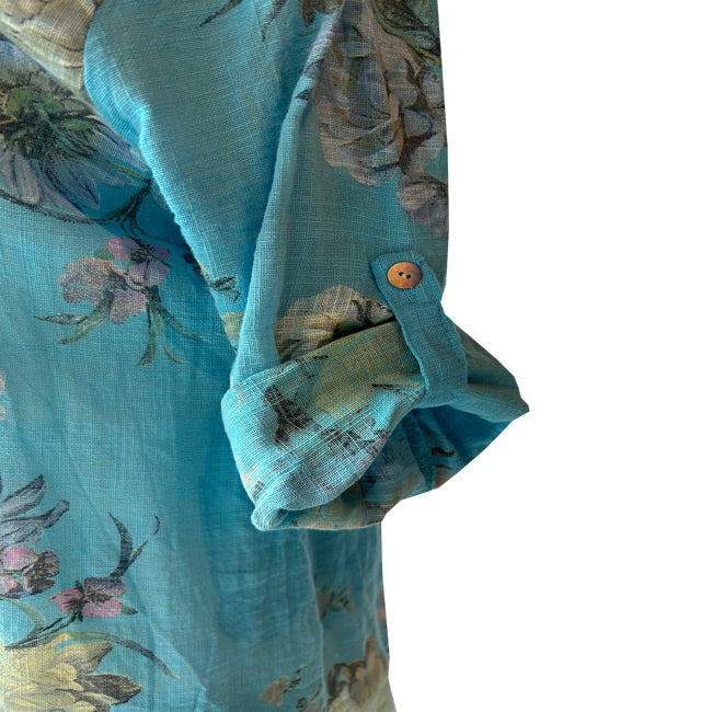 Cicek desenli turkuaz gomlegin kivrilip dugmelenmis kolu_Rolled up buttoned sleeve of patterned cyan blue shirt