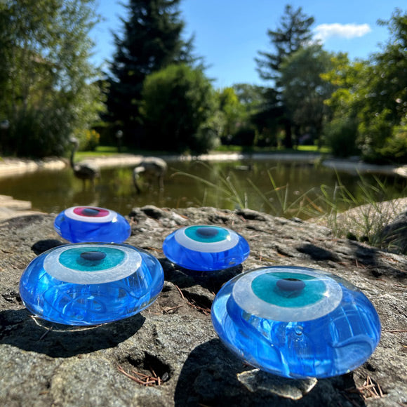 Golet kenarinda biri pembeli digerleri turkuaz mavi cam nazarliklar_Blue glass amulets beside the pond