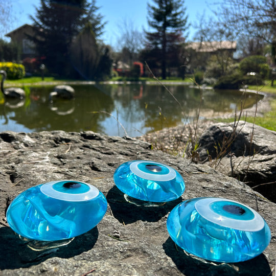 Golet kenarinda uc adet acik turkuaz nazarlik_Three light turquoise evil eye amulets beside the pond