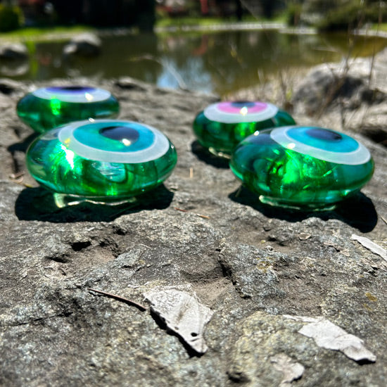 Golet kenarindaki kayada dort adet yesil buyuk nazarlik_Green big evil eye beads on the pond rock