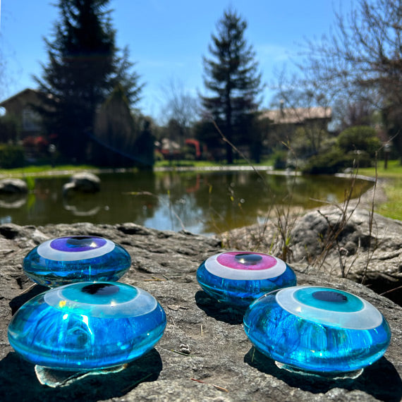 Golet yaninda turkuaz seffaf nazarliklar_Turquoise clear glass evil eye beads beside the pond