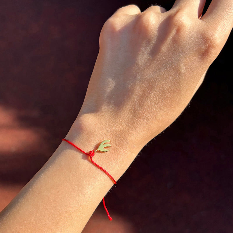 Kadin bileginde altin kaplama stilize kus motifli kirmizi ipli bileklik_Red string bracelet with gold plated stylized bird motif on woman wrist