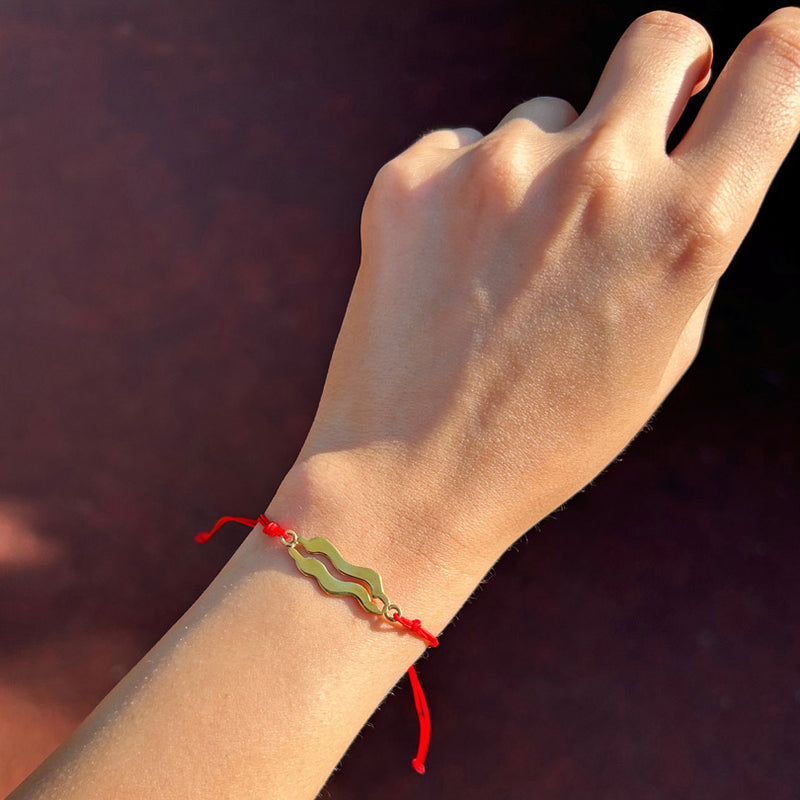 Kadin koluna takilmis yilan ejder motifli kirmizi ipli bileklik_Red string bracelet with serpent dragon motif on woman arm