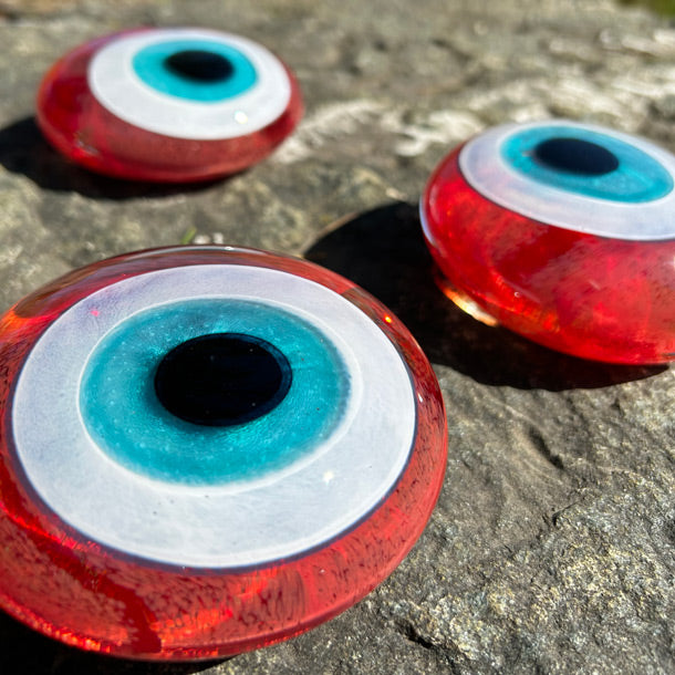 Kayada uc adet kirmizi dekoratif nazar boncugu_Three decorative red evil eye beads on the rock