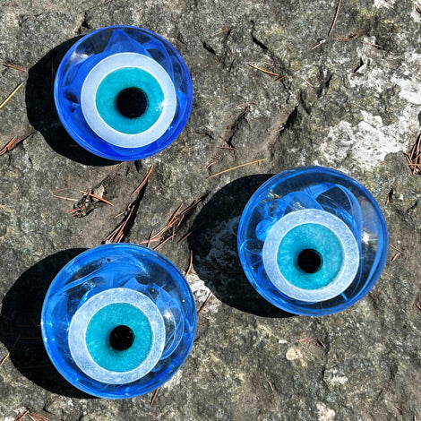 Kayada uc tane ici beyazli mavi nazar boncugu_Four blue evil eye beads on a rock