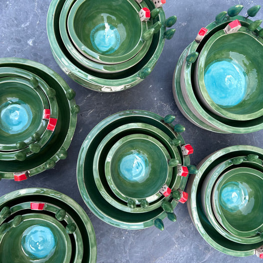 Kenarinda agaclar kirmizi catili evler olan ic ice yesil kaseler_Stacking green bowls with figurines