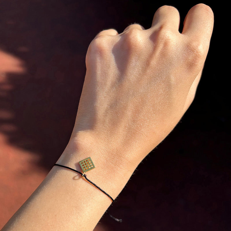 Kola takilmis Anadolu Motiflerinden bereket motifli siyah ipli bileklik_Black string bracelet with fertility motif among Anatolian Motifs on woman arm