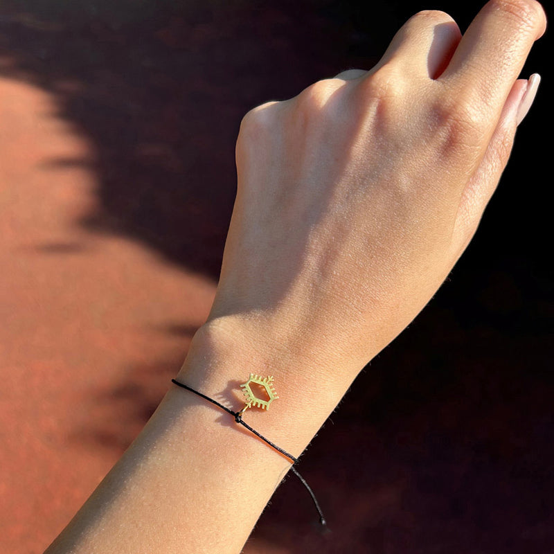 Kola takilmis Anadolu Motiflerinden pitrak motifli siyah ipli bileklik_Black string bracelet with burdock motif among Anatolian Motifs on woman arm