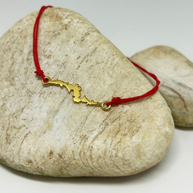 Kuvvet ve mutluluk sembolu yilan ejder motifi bir ciniden alinmis kirmizi ipli bileklik_Red string bracelet with serpent dragon motif symbolizing power and happiness
