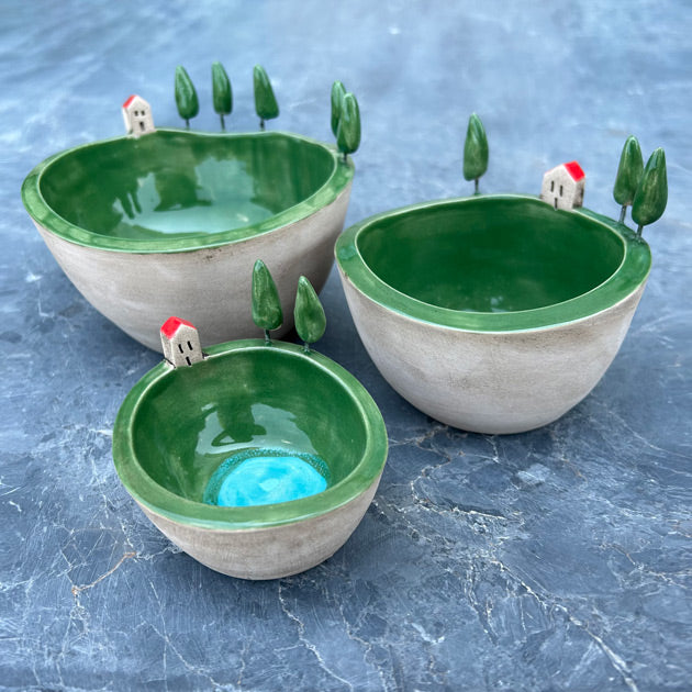 Mermer yuzeyde duran uc farkli boyda kenari suslu yesil kase_Three sized green bowls with figuines on the edge