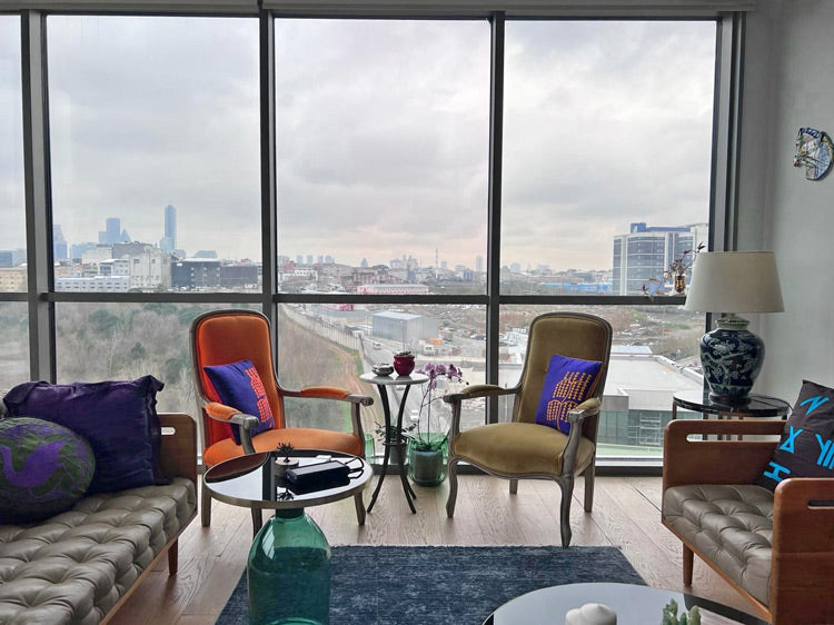 Penceresinden Maslak manzarasi olan salonda oturma grubu ve kirlentler_Seating group and cushions in the living room with Maslak view