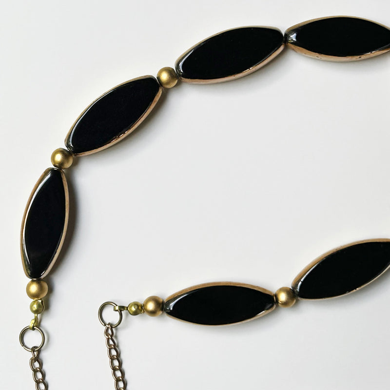 Sekiz adet altinli syah mekik seklinde boncuktan olusan kolye_Necklace composed of eight shuttle shaped golded black beads