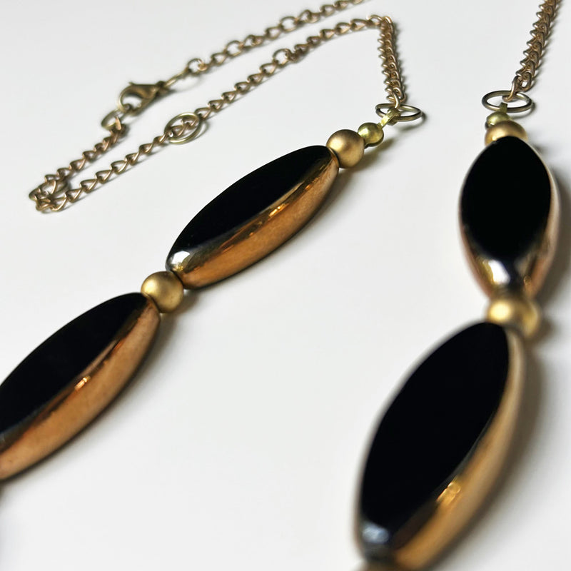 Sekiz adet altinli syah mekik seklinde boncuktan olusan kolye_Necklace composed of eight shuttle shaped golded black beads