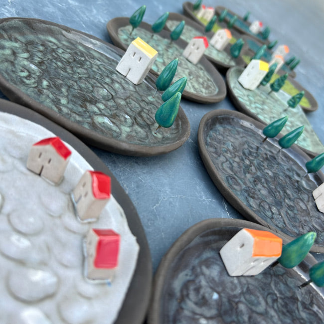 Ustlerinde minik evler ve agaclar olan yesil ve gri tonlarinda seramik tabaklar_Ornamental ceramic dishes in shades of green and gray