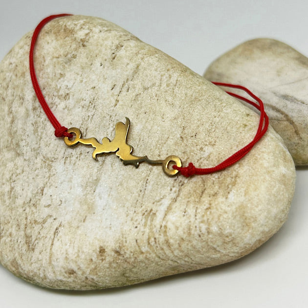 Yilan ejder motifi bir ciniden alinmis tasta duran kirmizi ipli bileklik_Red string bracelet with serpent dragon motif on beige stone