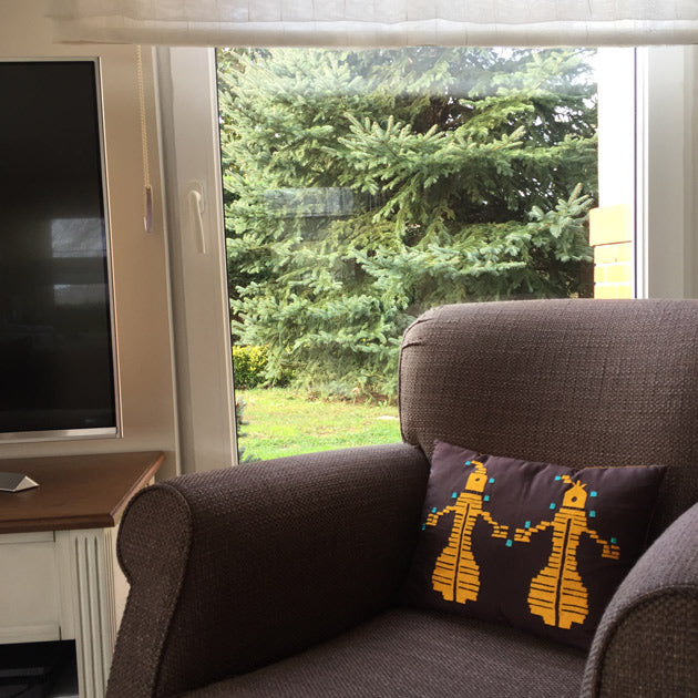 Bahce katinda kahverengi koltukta sari insan motifli aci kahve yastik_Yellow human motif embroidered brown cushion on the brown armchair