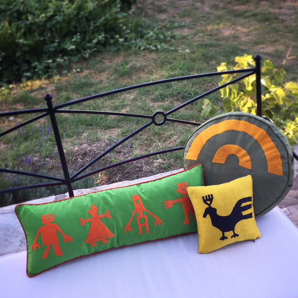 Bahcedeki siyah metal bankta yesil sari turuncu desenli yastiklar_Green yellow orange patterned pillows on a black metal bench in the garden