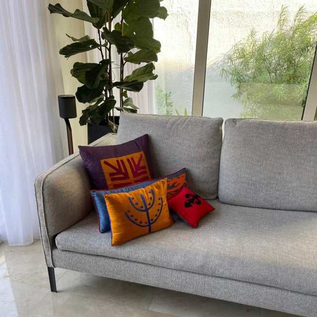 Bir Dubai evinde gri kanepede renkli desenli kirlentler_Patterned colorful cushions on a grey sofa