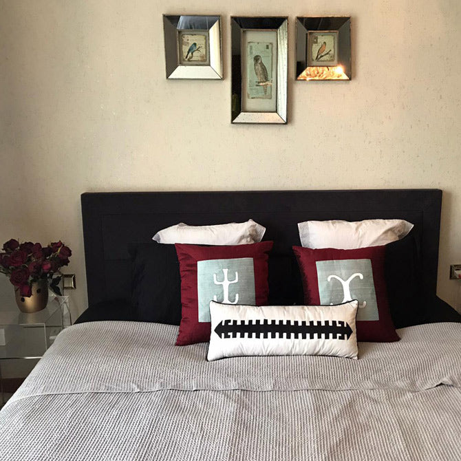 Cift kisilik yatakta kirlentler ve arkada tablolar_Silk pillows on the double bed and pictures at the back