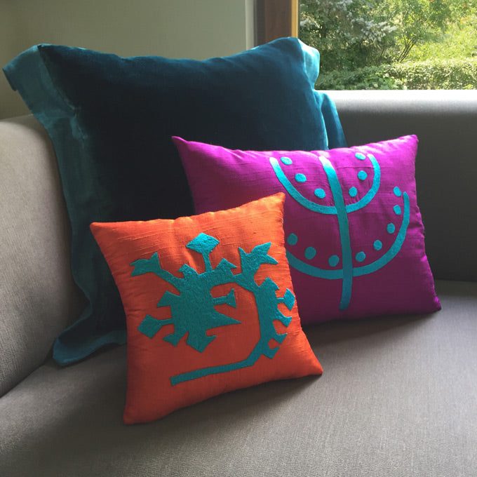 Pencerenin onundeki gri kanepede turkuaz turuncu fusya desenli ipek ve ipek kadife kirlentler_Turquoise orange fuchsia patterned silk and silk velvet cushions on the gray sofa by the window