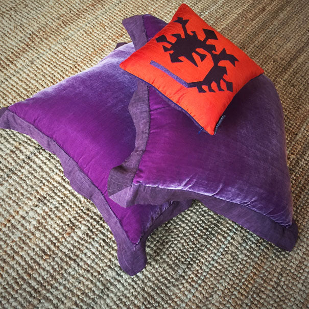 Koko hali ustunde turuncu ve mor ipek kadife ve ipek kirlentler_Orange and purple silk and silk velvet cushions on a coco carpet
