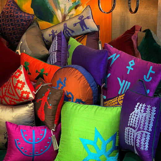 Magazada yigin ile islemeli renkli ipek yastiklar_A pile of patterned colorful silk throw pillows in the store