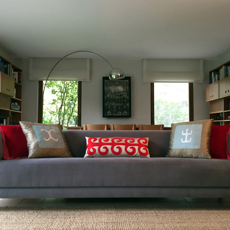 Salondaki kanepede kirmizi ve altin tonlarinda desenli ipek ve ipek kadife yastiklar_Patterned silk and silk velvet pillows in red and golden tones on the sofa in the living room