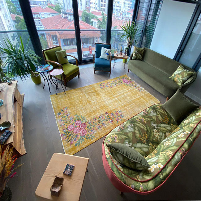 Sari halili salonda yesil ve desenli kanepeler_Green and patterned sofas in the living room with yellow carpet