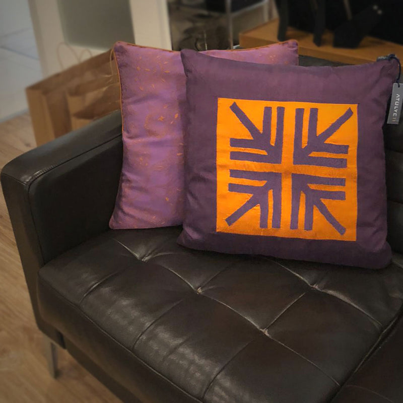 Siyah deri kanepenin kosesinde muska motifli mor ve turuncu yastik_Purple and orange pillow with amulet motif on the corner of the black leather sofa