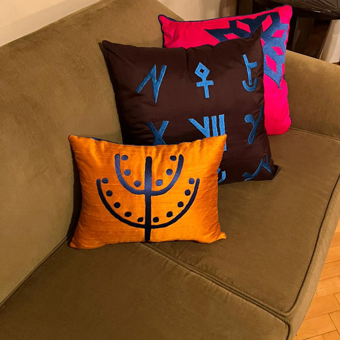 Tarcin rengi kanepede ardarda siralanmis canli renklerde uc yastik_Three cushions on a mustard colored sofa