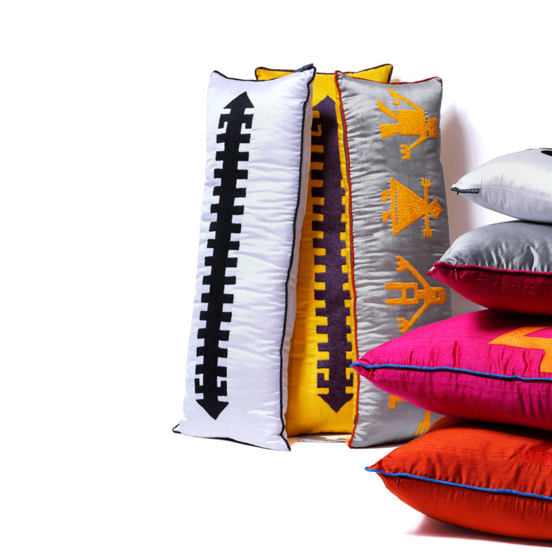 Ustuste renkli yastiklarin arkasinda desenli uzun dikey yastiklar_Patterned long vertical pillows behind colorful pillows on top of each other